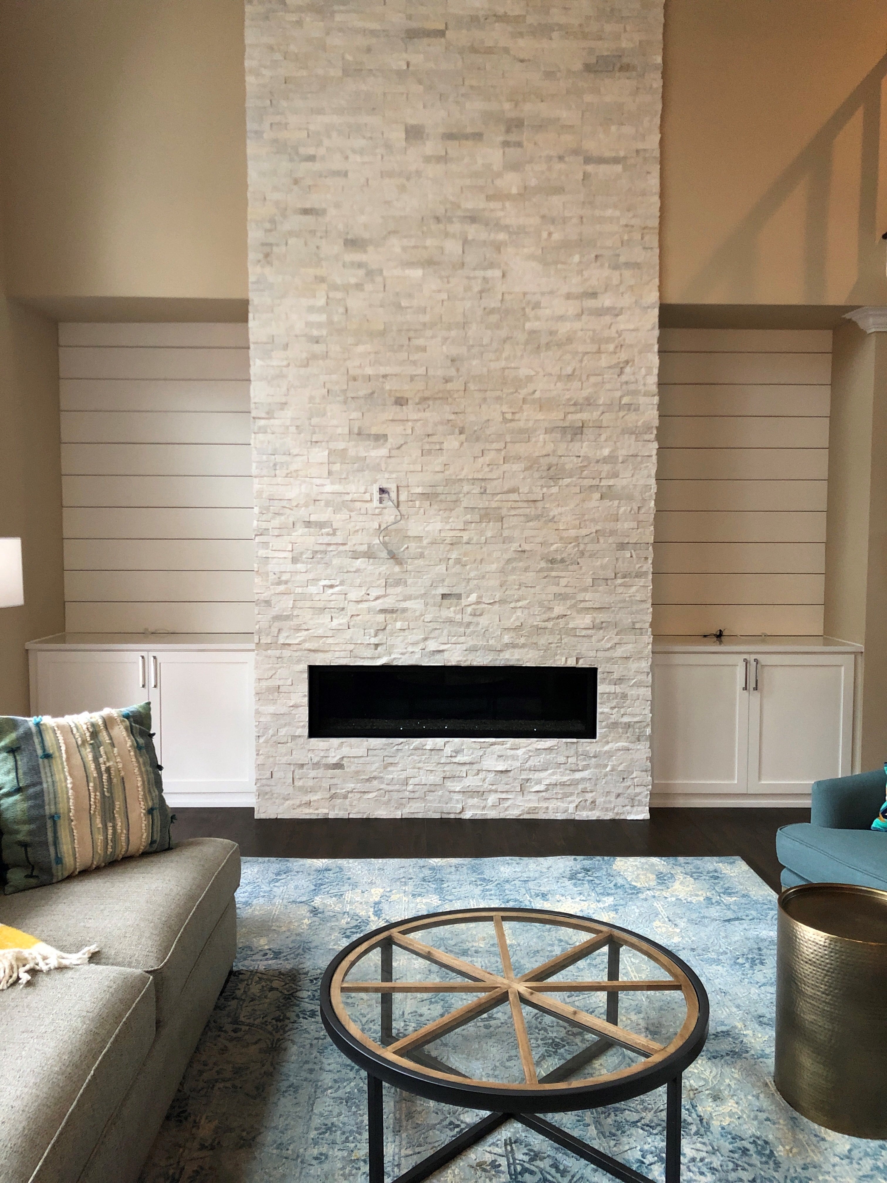 Norstone White Rock Panels used on a two story residential fireplace featuring a long linear fireplace and built in cabinets